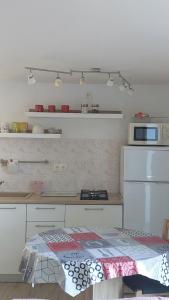 a kitchen with a counter with a microwave and a bed at Apartman Biba in Lubenice