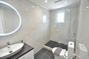 a white bathroom with a sink and a shower at Alexandra On The Beach in (( Litherés ))