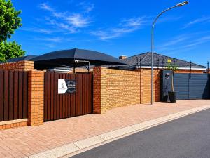 a brick fence with an umbrella on top of it at Hillcrest Hosting AirBnB in Kimberley