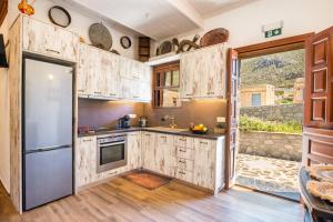 a kitchen with wooden cabinets and a large window at Lithos House in Avlóna