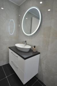 a bathroom with a sink and a mirror at Alexandra On The Beach in (( Litherés ))