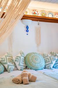 a bed with several pillows and a canopy at Lithos House in Avlóna