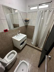a bathroom with a toilet and a sink and a mirror at Mini casita a in Rosario