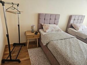 a bedroom with a bed and a table with a lamp at Elena Residence 15min from Belgrade in Pančevo