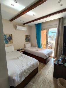 a hotel room with two beds and a balcony at Giza Pyramids Hotel in Cairo