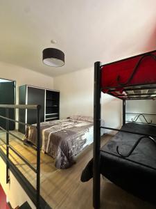 a bedroom with two bunk beds and a red bed at Mini casita a in Rosario