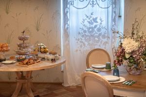 a table with food on it with a table with chairs at Il Borgo delle Pampare in Campello sul Clitunno
