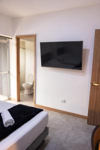 a bedroom with a bed and a tv on the wall at Komfort House Premium in Medellín