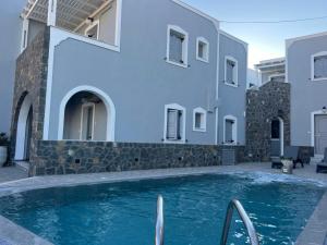 a villa with a swimming pool in front of a building at Kelenis Apartments in Karterados