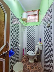 a small bathroom with a toilet and a window at Dev Palace in Uttarkāshi