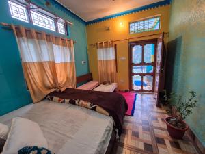 a bedroom with two beds and a window at Dev Palace in Uttarkāshi
