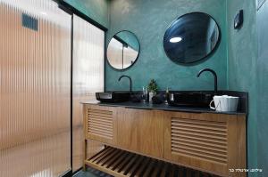 a bathroom with two sinks and two mirrors at Sagit luxury suites in Elqosh +43 photos