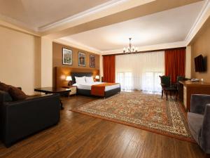 a hotel room with a bed and a couch at Cathedral Plaza Hotel in Gyumri