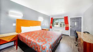 a bedroom with a bed and a desk and a window at Executive Inn Hondo in Hondo +21 photos