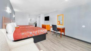 a hotel room with a bed and a desk at Executive Inn Hondo in Hondo