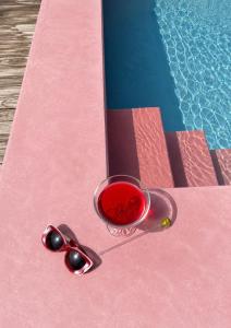 a glass of red wine next to a swimming pool at Apartamentos en la Rectoria de Regencós in Regencós