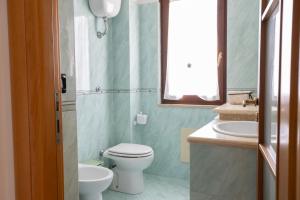 a bathroom with a toilet and a sink and a window at Villa Giglio Marino in Paestum +41 photos