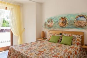 a bedroom with a bed with two green pillows at Villa Giglio Marino in Paestum
