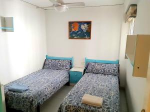 a room with two beds and a picture on the wall at La Rose in Gandía +24 photos