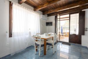 a dining room with a white table and chairs at Villa Giglio Marino in Paestum