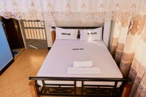 a bed in a room with two pillows on it at Marindo Lodge Moshi in Moshi