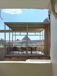 a balcony with tables and chairs and a view of a mountain at Giza Pyramids Hotel in Cairo