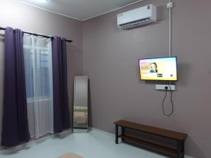 a living room with a tv and a mirror at IA Tiny House in Kampong Sura Tengah +7 photos