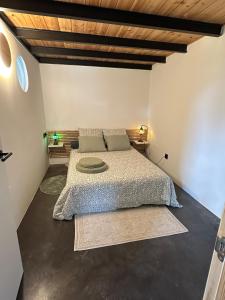 a bedroom with a large bed with a wooden ceiling at PASENIÑO - Aloxamento rural in Palas de Rei