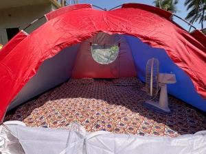 a red and blue tent with a bed in it at Sea front tent house in Murud