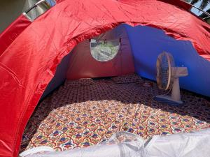 a red and blue tent with a fan in it at Sea front tent house in Murud