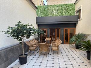 a patio with chairs and a table and a plant at Hotel Bogatt in Dushanbe