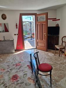 a living room with a door and a chair and a table at Bracchi's room franciacorta in Cazzago San Martino