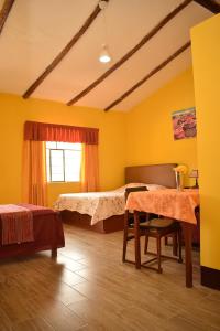 a room with a bed and a table in it at Los Portales de Yungar Ecolodge Huaraz in Carhuaz
