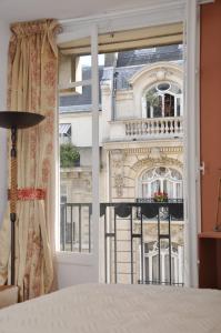 a bedroom with a view of a building through a window at Champs Elysees Executive Apartment in Paris