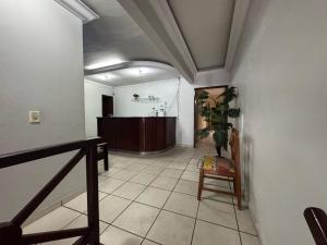 a hallway with a waiting room and a chair at hotel vitoria in Campina Grande
