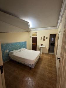 a bedroom with a bed and a table in it at hotel vitoria in Campina Grande