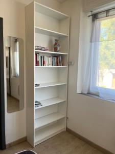a book shelf in a room with a window at Le Quai Confort T2 - in Ax-les-Thermes