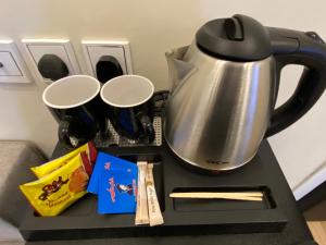 a table with a tea kettle and some snacks at شقة هادئة مودرن in Al Khobar