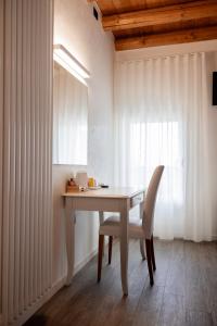 a white table with a chair and a window at locazione turistica PetitePomme in Borso del Grappa