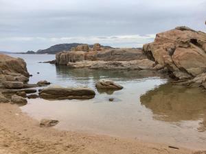 a body of water with rocks in the water at Perla di mare in La Maddalena +6 photos