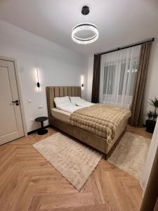 a bedroom with a large bed and a large window at Aura Home - Livezeni Hiperbara in Livezeni