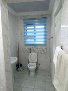a bathroom with a toilet and a sink and a window at Mypeace Comfort in Pretoria +23 photos