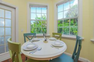 a dining room with a table and chairs and windows at Villa Florence in Holmes Beach +48 photos