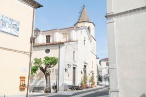 a building with a tree in front of a street at Palia's Hotel in Laino Borgo