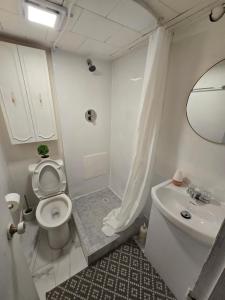 a white bathroom with a toilet and a sink at Brossard room 3 in Brossard