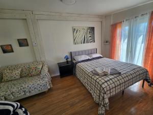 a bedroom with a bed and a couch at Brossard room 3 in Brossard