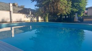 a swimming pool with blue water in a yard at Il Nibbio in Vecchiano