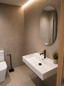 a bathroom with a white sink and a mirror at Pensión O Novo in Treacastela