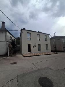 a white building sitting on the side of a street at Pensión O Novo in Treacastela