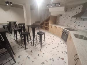 a kitchen with four tables and stools in it at Pensión O Novo in Treacastela